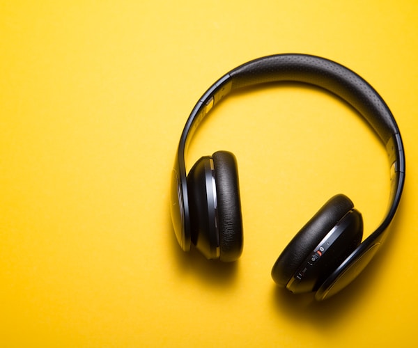 Black Wireless Headphones on a Yellow Background